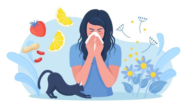 A person blowing their nose into a tissue with a cat beside her as well as flower pollen.