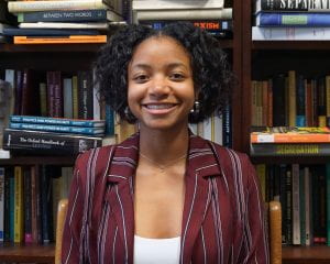 Headshot of Kailah Jeffries sitting in front of a bookshelf.
