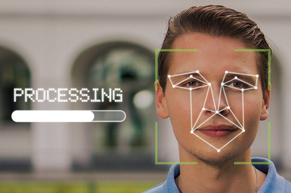 Man with facial recognition graphic with words "processing" next to him