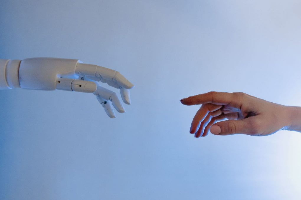 Robot hand reaching out to a human hand in the style of the Michelangelo painting The Creation of Adam