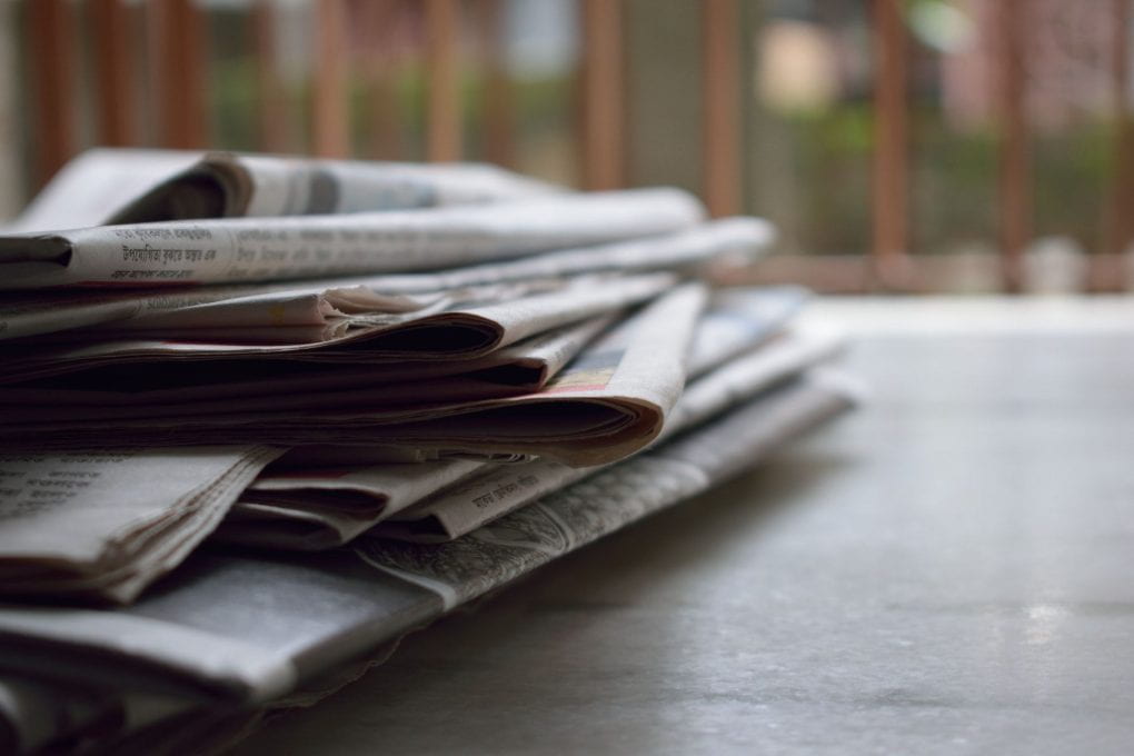 Selective focus photograph of stack of newspapers