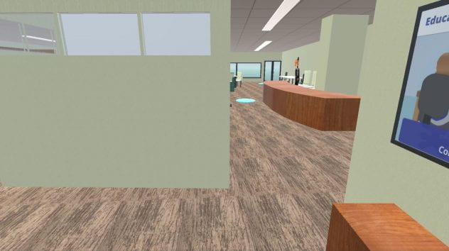 View of walking space with mostly carpet visible. A wood desk with a person standing behind it is visible ahead.