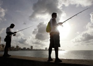 Cubans enjoy fishing in the calm sea along Havana seafront boulevard El Malecon.