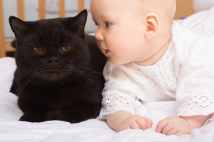 Cute five month baby with black cat